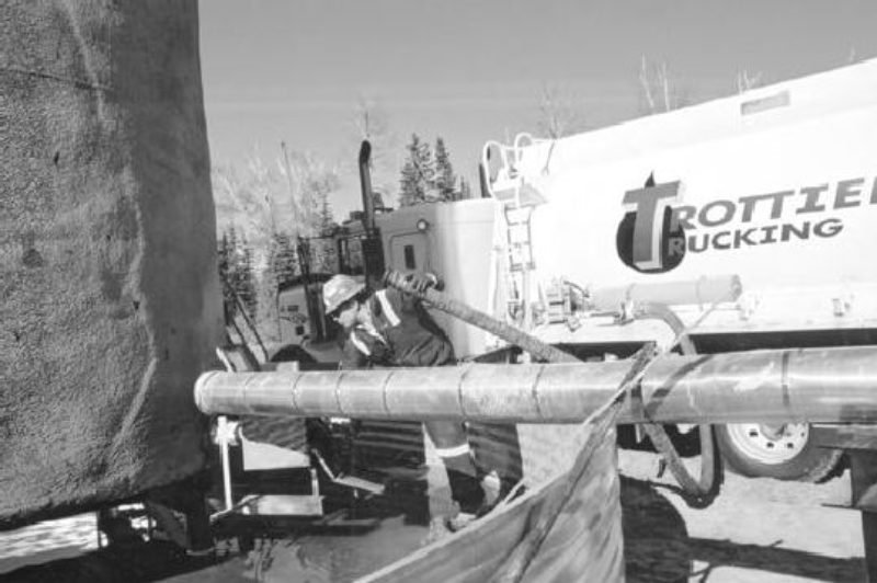 HAZARDOUS STUFF: Len Fletcher loads his truck up with produced water which is then recycled back into the ground.Photo by James Menzies