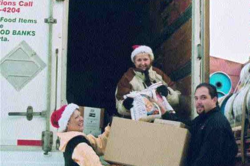 CHRISTMAS SPIRIT: Organizers Colleen Nickel and Dale Hart accept a donation from Manitoulin Transport sales professional, Michael Davis in Calgary. Photo by Evalee Sommerfeldt