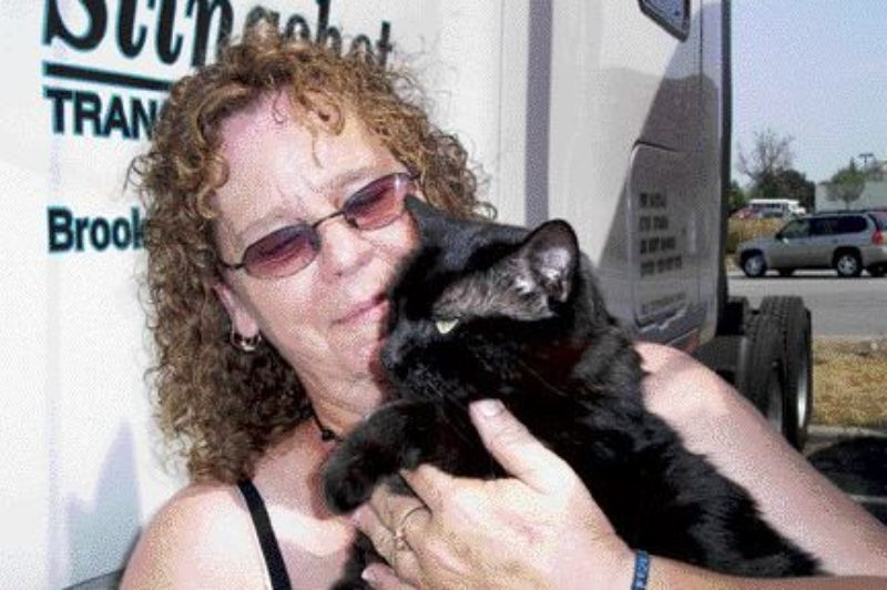 TWO CATS: Kat and one of her two cats take a break on a hot afternoon in July. Photo by Adam Ledlow