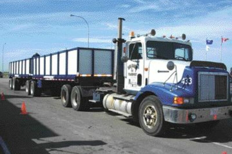 ALL BOXED IN: With cargo securement on everyone's mind these days, Big Horn Transport has found a creative way to ensure its drivers are in compliance. This b-train consists of two standard flatdecks which have been modified to help make sure the cargo stays where it belongs. Big Horn controlling officer, Philip Blasetti, says the company has modified several of its flatdecks by adding walls consisting of steel stanchions and 3/4-inch plywood. He says it only adds about 500 lbs to each of the trailers. The center section can be easily removed allowing the load to be added or removed by forklift. Blasetti says the load must still be secured as though it were on a traditional flatdeck, but the walls provide some extra peace of mind that the cargo isn't going to get away. 