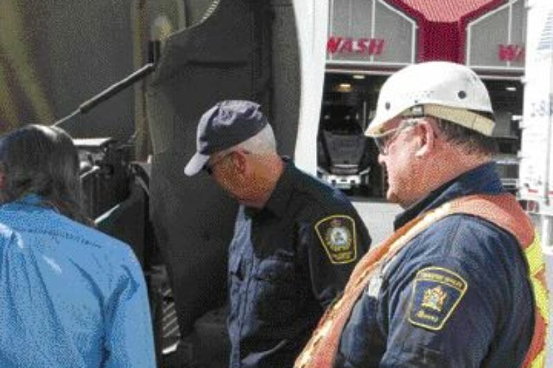 FREE LOOK-SEE: Inspection officers Terry Polreis (right) and Vic Butlin perform a voluntary brake inspection on a Kindersley Transport truck. The truck was in compliance and its driver soon on his way.Photo by James Menzies