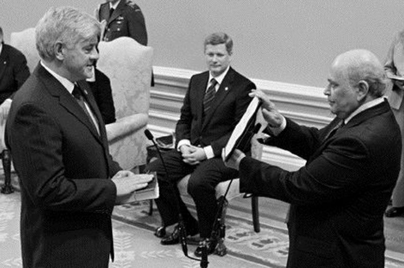 SWEARING IN: Newly-crowned Prime Minister Stephen Harper looks on as Transport Minister Lawrence Cannon is sworn into Parliament. Harper's Conservatives now form a minority government.Photo by Canadian Press