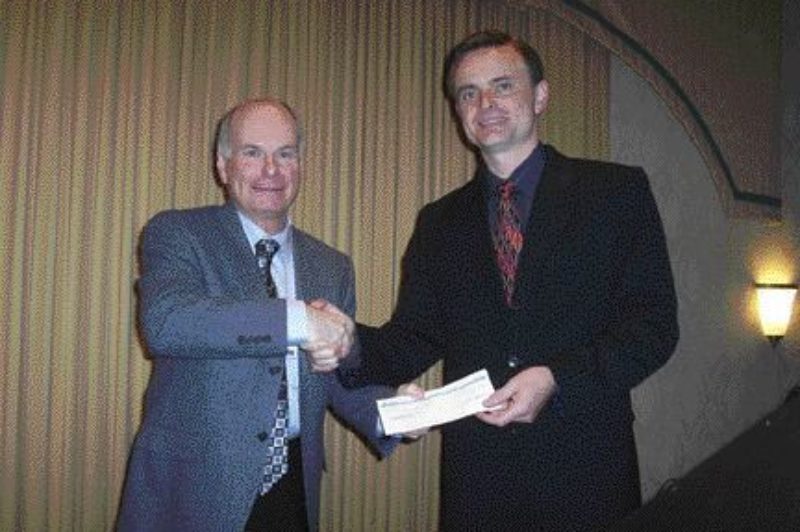 HELPING HAND: David Marshall of the Fraser Basin Council receives a check from B.C. Environment Minister Barry Penner for biodiesel outreach work.