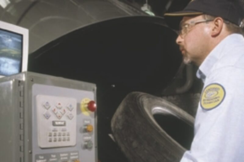 NEW TECHNIQUES: A Bandag technician uses a shearography machine to detect small bubbles that are invisible to the human eye. Just one of many advances in retreading technology that the best retreaders now employ.