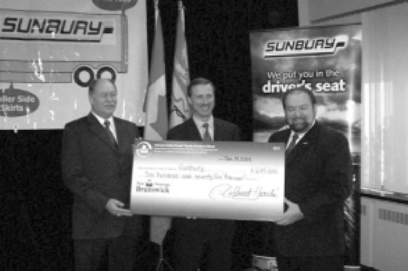 HELPING OUT: Minister of Environment Roland Mache (left) and Minister of Transportation Denis Landry (right) present Sunbury's vice-president of transportation, John Murphy, with a cheque for $675,000 to fund the installation of APUs in Sunbury's owner/operator fleet and the launch of a trailer skirt pilot program.