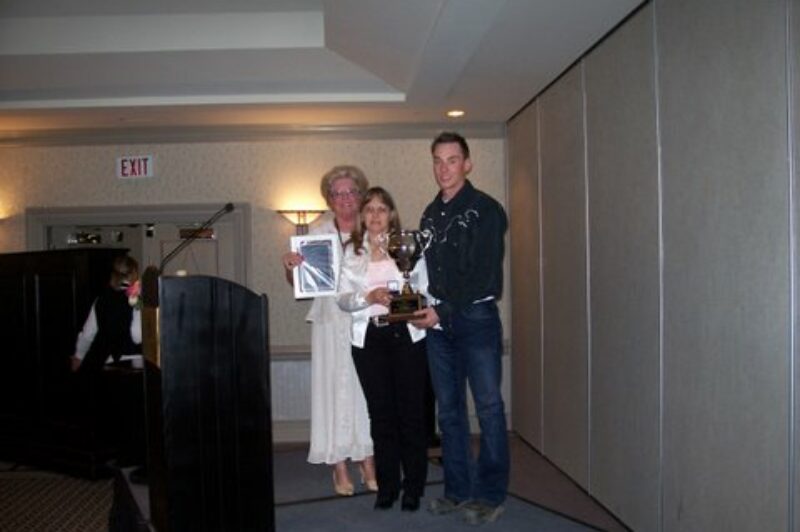 Marie Hibbard (left) presents the AMTA's safety award posthumously to John Tessier via his wife Chris and son Tyler at the AMTA convention in Banff.
