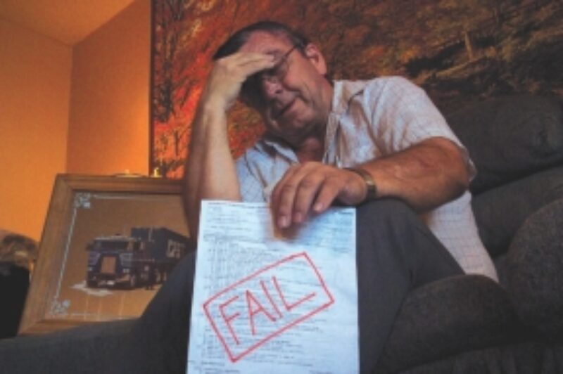 BREAKING POINT: Norman Moore, shown the day before his 65th birthday, recently failed his practical air brake test conducted by DriveTest, despite 46 years of safe driving. He feels it was an arbitrary failure that didn't reflect his abilities as a professional driver. Moore was planning to attempt the test one more time before downgrading. Pictured at his side is a cherished photo of Moore with his former truck, taken in 1979.