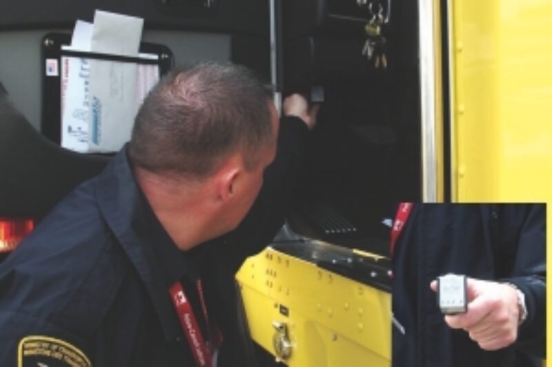 CHARGES PENDING: MTO inspector Travis McMunn demonstrates how enforcement officers will check for compliance with Ontario's speed limiter law. A wireless device (inset) plugs into a slot under the dash to reveal speed limiter settings.