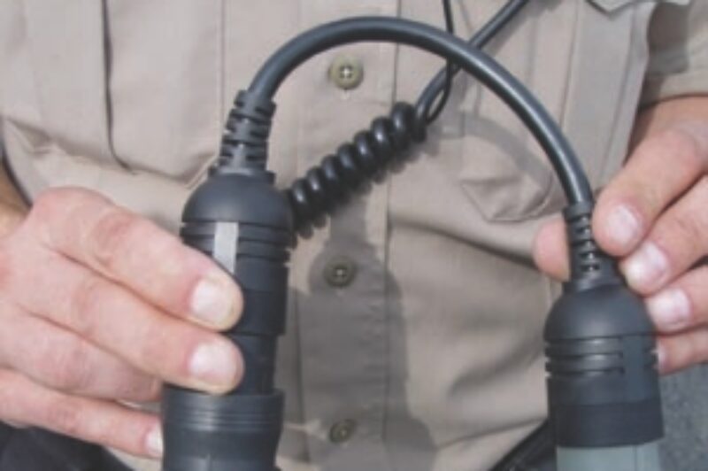 TOOLS OF THE TRADE: A Quebec enforcement officer shows the connection device used to read a truck's speed limiter setting. And yes, it can read the cruise speed too. Photo by Carroll McCormick