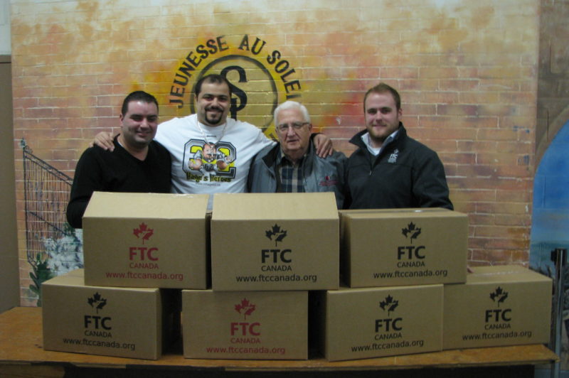 CFLer Marwan Hage (second from left), FTC Canada's Ryan Fletcher (far right) and staff from Sun Youth were on hand to distribute food boxes in Montreal last week. Keltic Transportation offered its services to help make deliveries during the event.