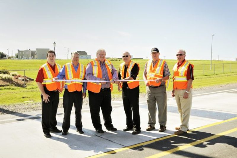 Minister of Transportation and Infrastructure Renewal Ron MacKinley and Minister of Agriculture George Webster are joined by (L-R): Tyson Kelly, director with the Atlantic Provinces Trucking Association; Michel LeChasseur, general manager of the Confederation Bridge; Willard MacDonald, a local trucker; and Donnie Corrigan, executive director of the PEI Trucking Association, at a ribbon cutting ceremony for the new weigh-in-motion device in Borden-Carleton.