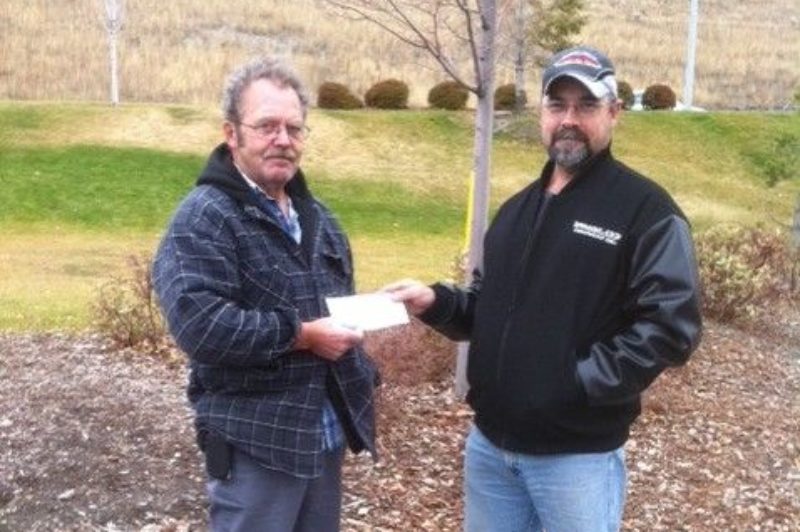 Alex Fraser (left), receives a cheque from NATG founder Larry Hall.