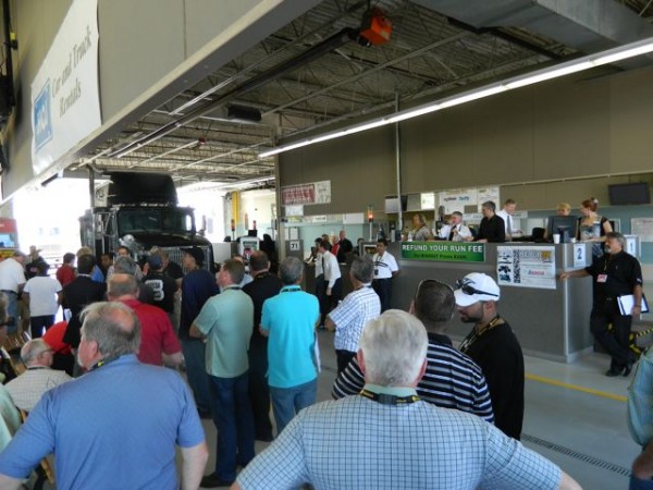 Potential buyers gather around to bid on an International tractor.
