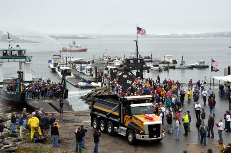 LPA officials and community members greet the Cat CT660 the company won in the Win a Cat Truck contest. The truck arrived via one of LPA's own barges.