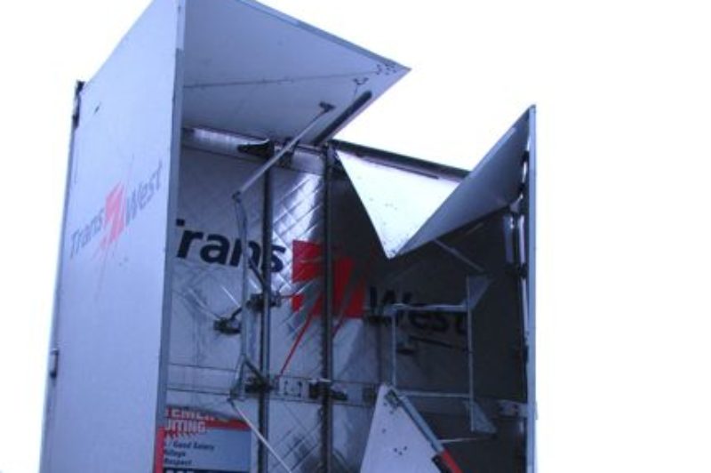 Trans-West fleet director Michel Morin opens a fuel-saving TrailerTail from ATDynamics. (Photo by Carroll McCormick)