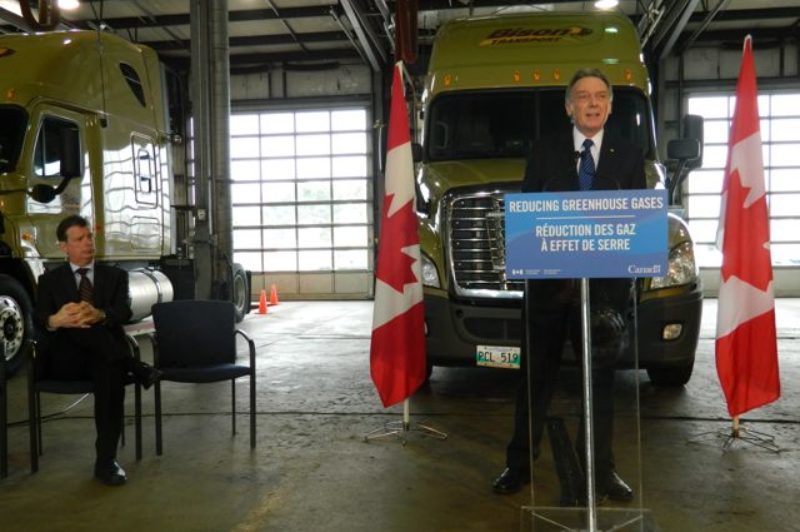 CTA's David Bradley looks on as Environment Minister Peter Kent announces Canada will follow the US lead when it comes to adopting GHG standards for heavy trucks.