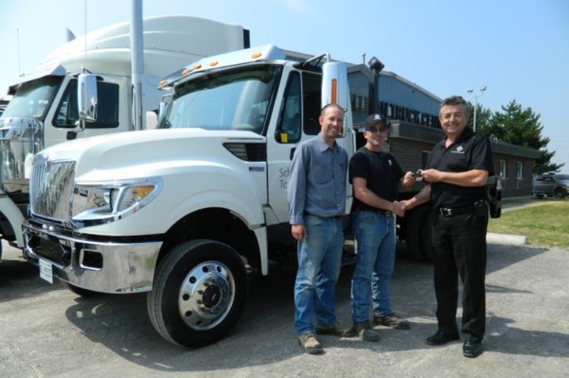 Tallman Truck Centre's Harvey Butcher (right) hands the keys to the company's first TerraStar 4x4 to Schindler Elevator driver Adam Maisonneuve, while Schindler's field supervisor Jeff Couch looks on.