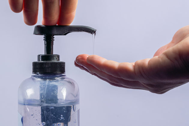 Close-Up Shot of Caucasian Male Hand Pumping Small Flow of Gel Hand Sanitizer with Alcohol and Aloe Vera To Prevent the Spread of COVID SARS nCoV 19 Coronavirus Swine Flu H7N9 Influenza Illness During Cold and Flu Season alternate text for this image