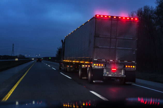Expressway Speeding Car Driver POV Passing Illuminated Semi Trailer Truck alternate text for this image