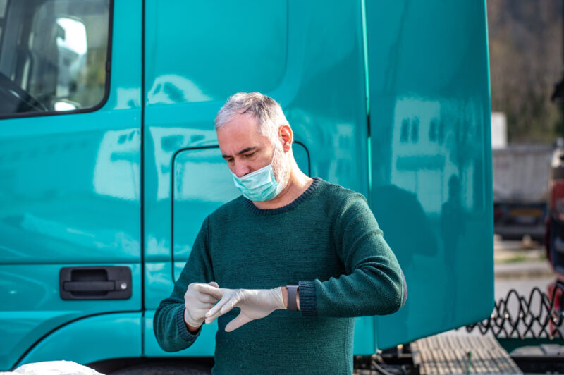 Truck driver with white gloves and face mask