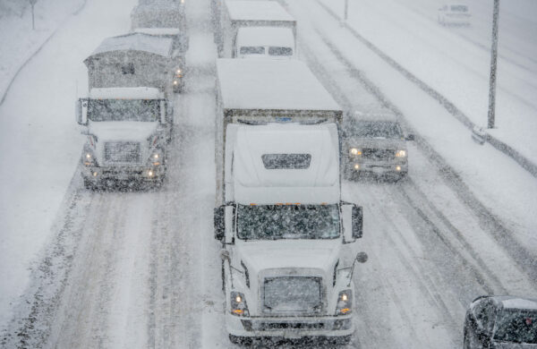 Semi truck traffic on Interstate 5 during a winter snow and freezing rain storm