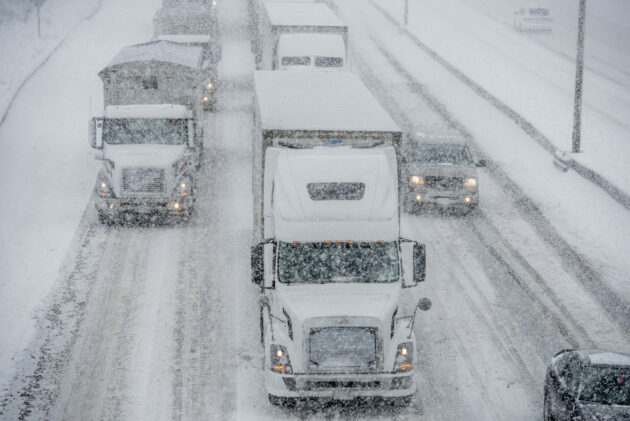 Semi truck traffic on Interstate 5 during a winter snow and freezing rain storm