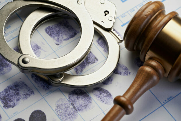 Gavel and handcuffs on fingerprints: Arrest crime concept