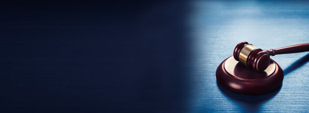 judge gavel on a blue wooden background alternate text for this image