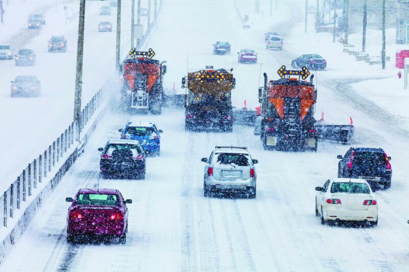 Tree Lined-up Snowplows Removing the Snow the Highway on a Cold Snowy Winter Day