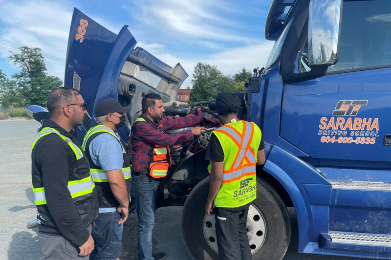 Amrit Grewal shows students how to inspect an engine.