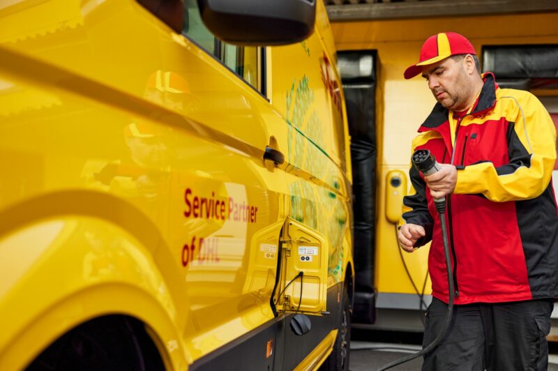 Picture of a DHL Express driver plugging in an electric vehicle