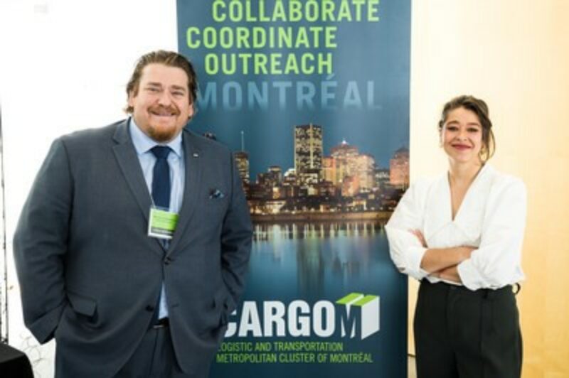 People standing in front of a CargoM poster