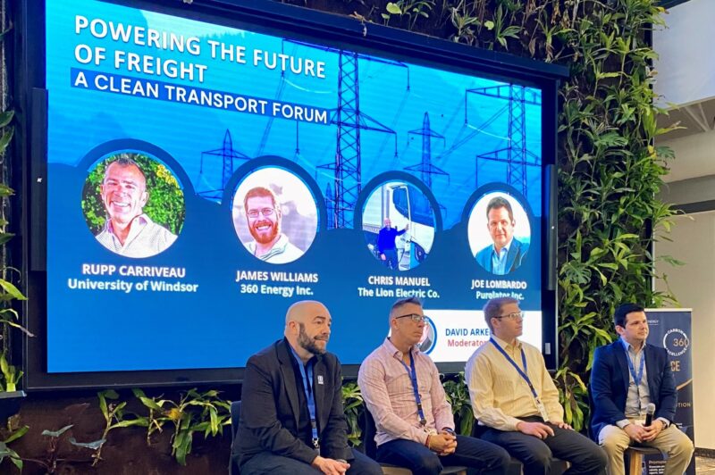 Four men sitting on stools during a discussion