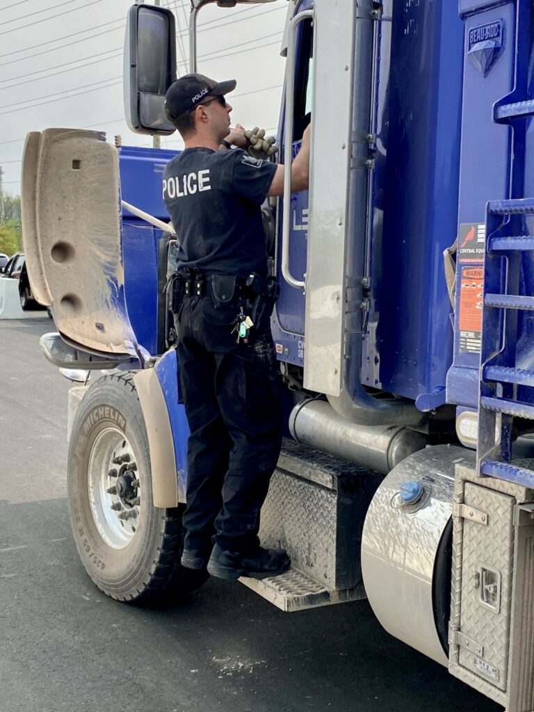 Police officer on the step of a truck