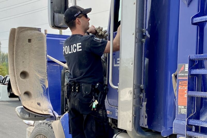 Police officer on the step of a truck