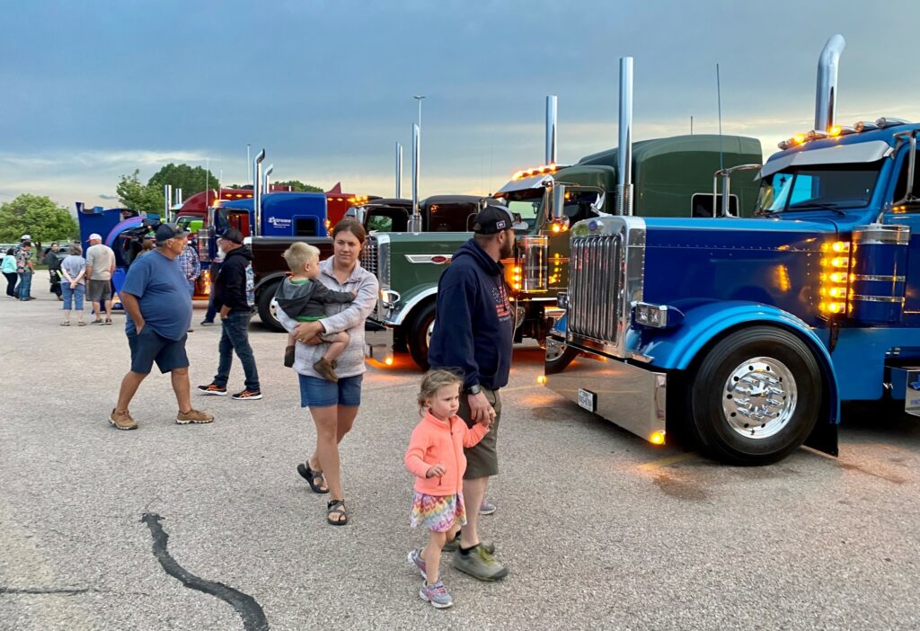People walking past parked trucks