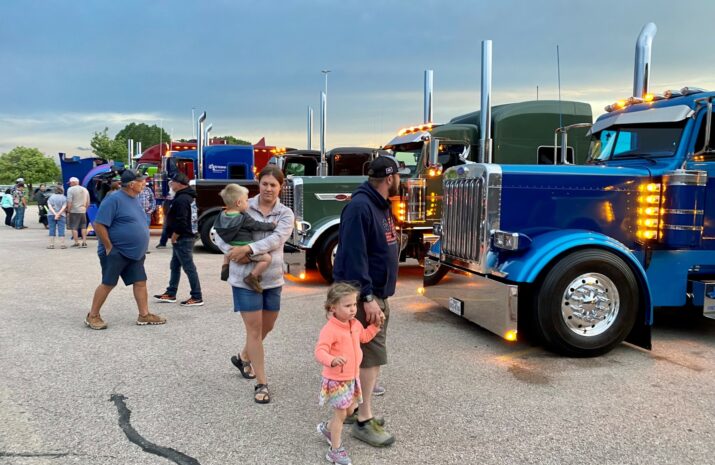 People walking past parked trucks