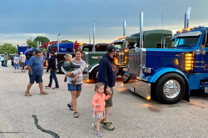 People walking past parked trucks