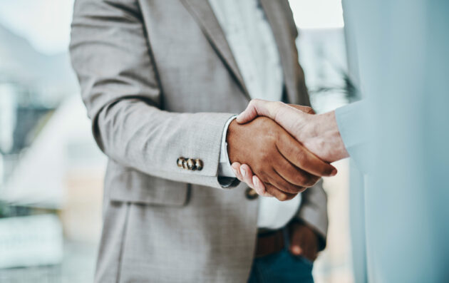 Shot of a businessman and businesswoman shaking hands in a modern office alternate text for this image