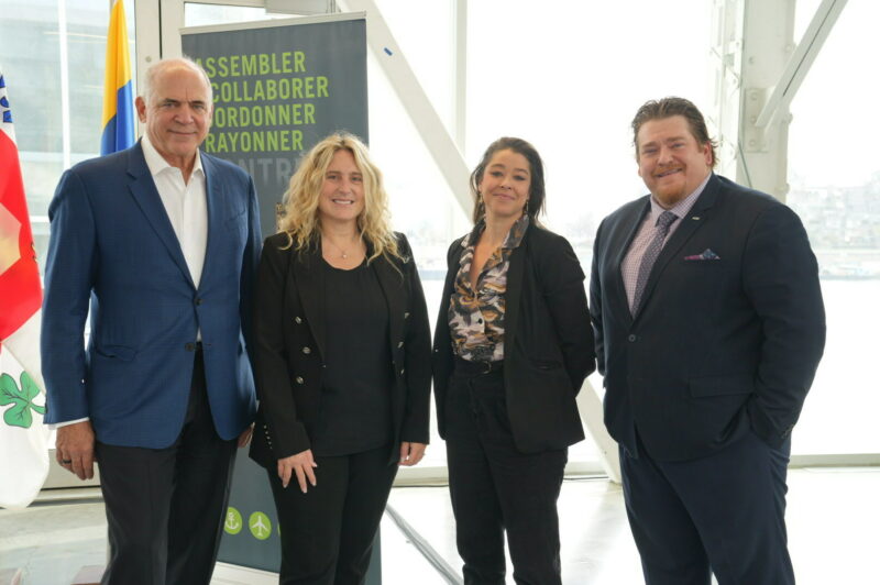 The image is of four CargoM executives in front of the banner