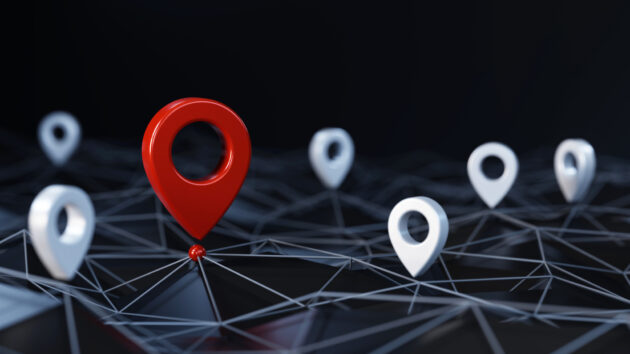 Red unique map pin / location pin icon surrounded other small ones on the abstract geometric low polygonal surface with plexus effect alternate text for this image