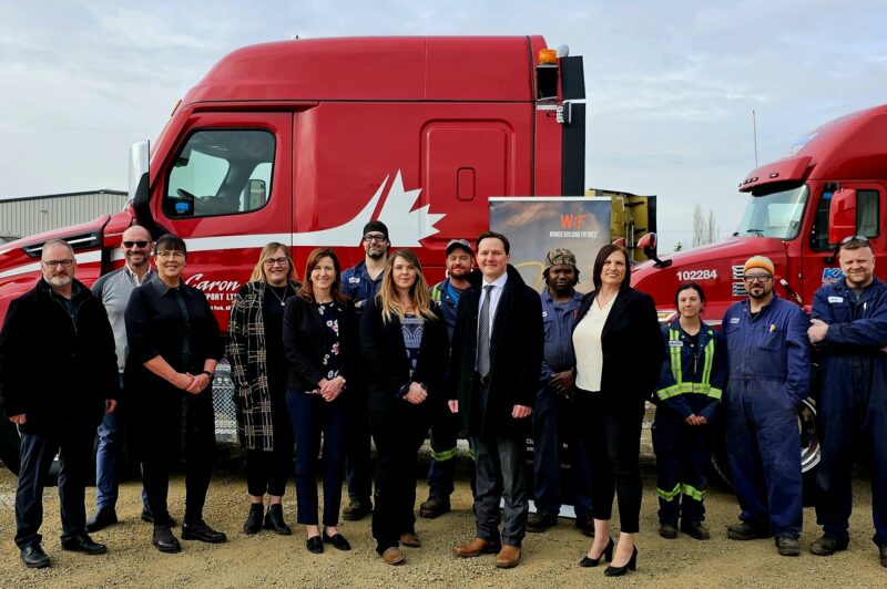 the image is of the government officials in front of the red truck on the day of the grant announcement