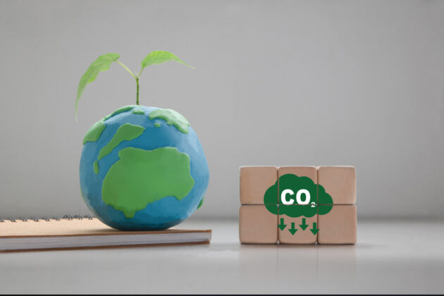 CO2 emission concept, tree planting concept. Zero net emissions, renewable energy, sustainable technology Ecological Solutions wooden cube with CO2 reduction icon, Earth Day alternate text for this image