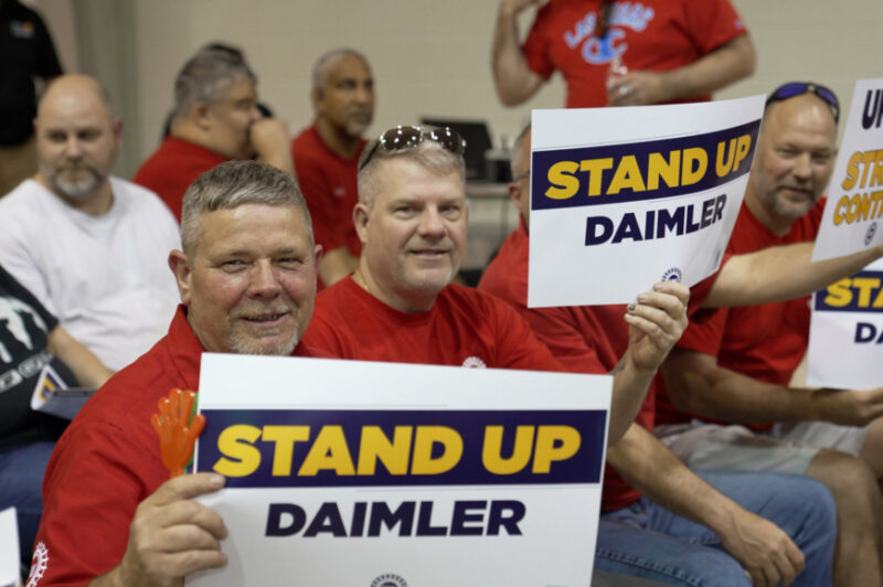 Workers holding up signs