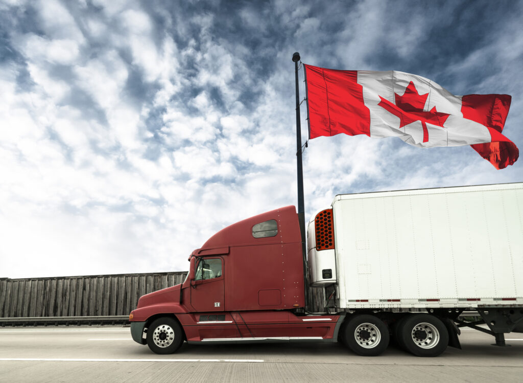 Truck on a highway with Canadian flag behind it