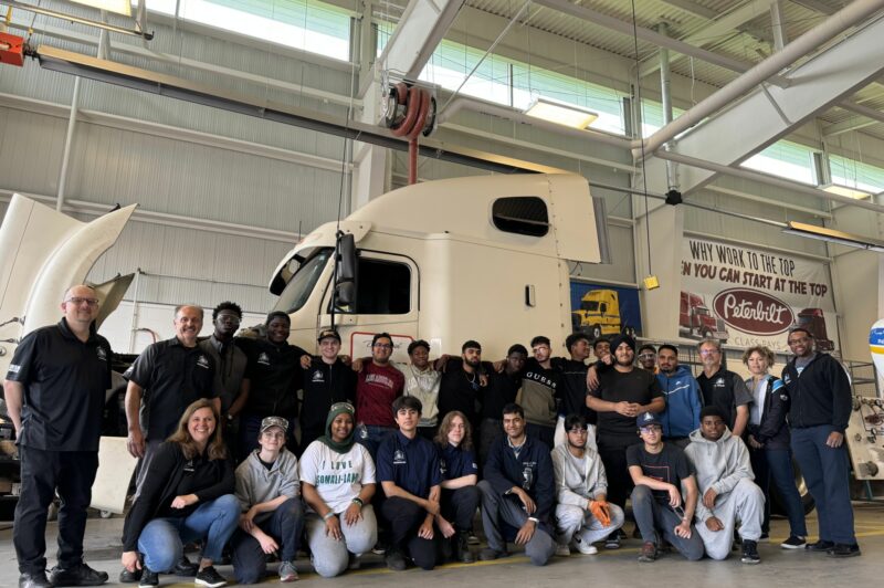 Bramelea transportation program students with their teachers in the shop in front of a truck