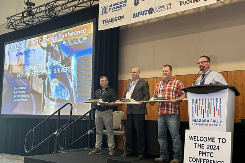 Four drivers standing on the stage with awards as they have been inducted into the Hall of Fame for Professional Drivers