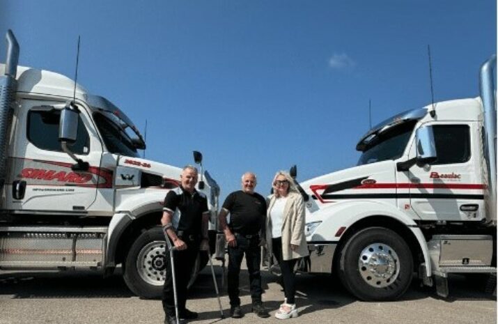 Picture of three people and two trucks