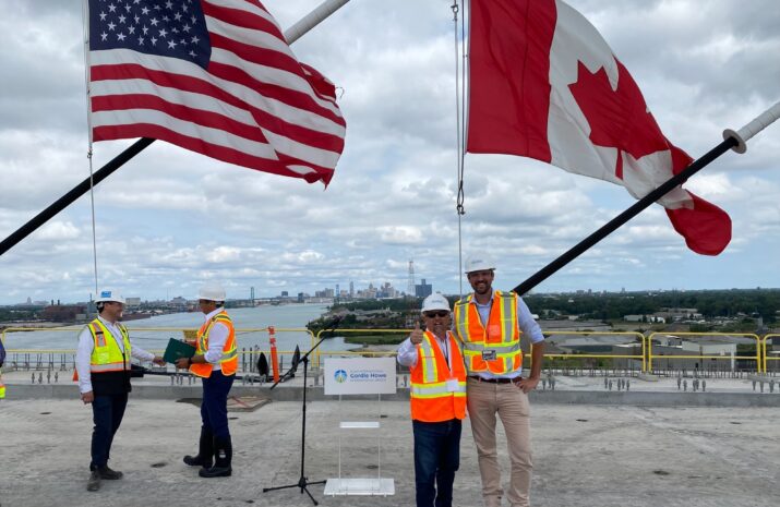 People on the bridge crossing with American and Canadian flags