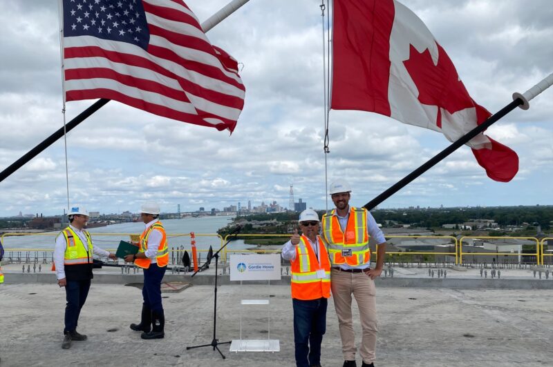 People on the bridge crossing with American and Canadian flags